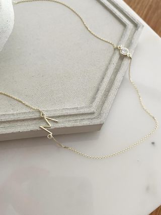 ✨ Unikátní kousek, který nese osobní příběh. Ručně tvarované písmeno na přání a zirkon zasazený do jemného zlatého řetízku...